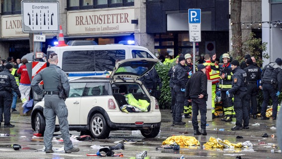 13.02.2025, Bayern, München: Polizisten untersuchen ein Auto in der Nähe des Einsatzortes. In der Münchner Innenstadt ist ein Fahrzeug in eine Menschengruppe gefahren. © Peter Kneffel/dpa Foto: Peter Kneffel