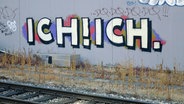 Auf einem Bahnhof ist an eine Wand ein Graffiti "Ich! Ich." gesprüht. © picture alliance / ZB | Sascha Steinach 
