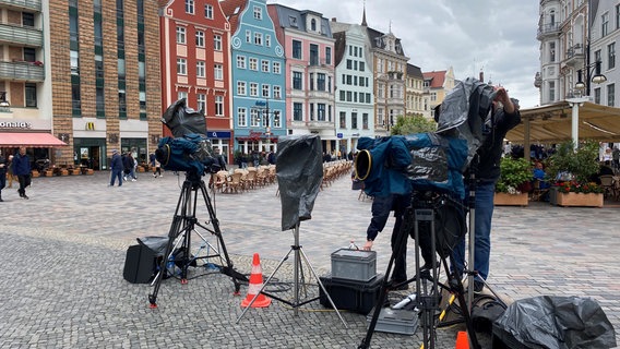 NDR Info sendet Nachrichten live aus Rostock. Das NDR-Equipment wird abgedeckt, da es über den Tag immer wieder stark regnet. © NDR Foto: Maximiliane Repp