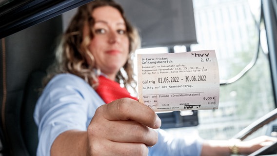 Eine Busfahrerin gibt einem Kunden in einem Hamburger Bus sein Neun-Euro-Ticket. © dpa/Markus Scholz Foto: Markus Scholz
