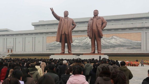 In Pjöngjang stehen Menschen vor den Statuen der ehemaligen Führer Kim Il Sung und Kim Jong Il. © Cha Song Ho/AP/dpa 