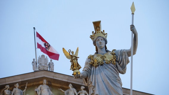 Ein Blick auf die Statue der griechischen Göttin der Weisheit, Pallas Athene, vor einer österreichischen Flagge auf dem österreichischen Parlament. © dpa Foto: Heinz-Peter Bader