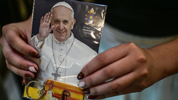 Eine Frau hält ein Foto in der Hauptkirche von Buenos Aires bei einer Messe für die Gesundheit von Papst Franziskus. © dpa bildfunk Foto: Fernando Gens