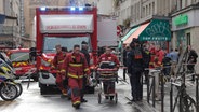Feuerwehrsanitäter arbeiten am Tatort in Paris © Lewis Joly/AP/dpa 