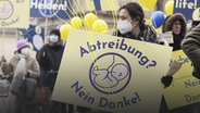 Eine Frau nimmt an einer Demonstration von Abtreibungsgegnern unter dem Titel "Marsch fürs Leben" teil und trägt ein Schild mit der Aufschrift "Abtreibung? Nein Danke!" © picture alliance Foto: Tobias Hase