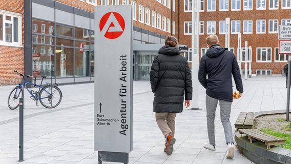 Ein Schild mit der Aufschrift "Agentur für Arbeit" steht vor dem Eingang der Hamburger Agentur für Arbeit am Nagelsweg im Stadtteil St.Georg. © picture alliance/dpa Foto: Markus Scholz