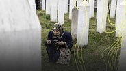 Eine Frau betet an einer Gedenkstätte während des Gedenkens an das Massaker von Ahmici in Vitez, Bosnien und Herzegowina. © picture alliance Foto: Samir Yordamovic