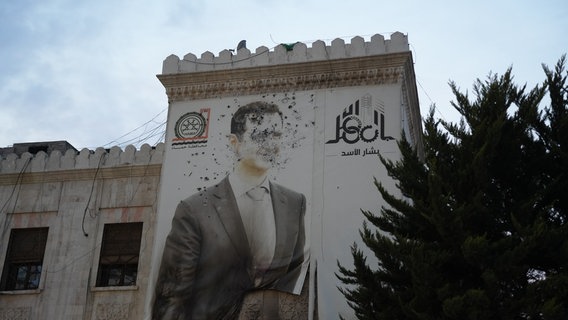 Auf dem Marktplatz im syrischen Homs wird die Befreiung von Diktator Assad mit Freudenschüssen gefeiert. © picture alliance Foto: Rami Alsayed