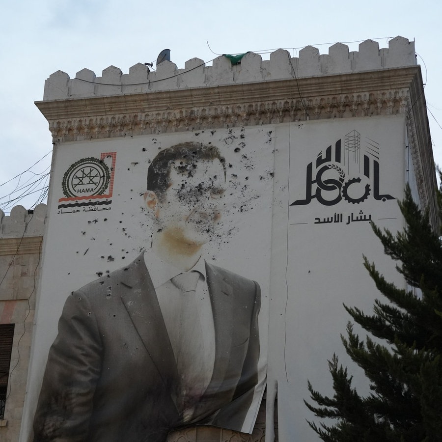 Auf dem Marktplatz im syrischen Homs wird die Befreiung von Diktator Assad mit Freudenschüssen gefeiert. © picture alliance Foto: Rami Alsayed