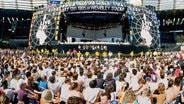 Eine riesige Menschenmenge besucht das Live Aid-Konzert zur Hungerhilfe für Afrika im Wembley-Stadion am 13.7.1985. © dpa/empics Foto: Duncan Raban