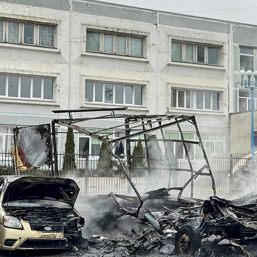 Zerstörte und verbrannte Autos und ein beschädigtes Gebäude nach einem Beschuss der Ukrainer in der russischen Grenzregion Belgorod. © Vyacheslav Gladkov's/Telegram/Belgorod region governor Vyaches/AP/dpa 