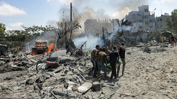 Palästinenser evakuieren eine Leiche von einem Ort, der von einem israelischen Bombardement im südlichen Gazastreifen getroffen wurde. © AP Foto: Jehad Alshrafi