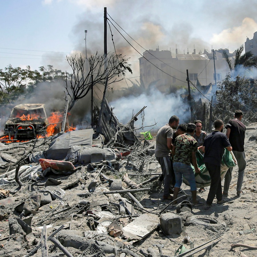 Palästinenser evakuieren eine Leiche von einem Ort, der von einem israelischen Bombardement im südlichen Gazastreifen getroffen wurde. © AP Foto: Jehad Alshrafi