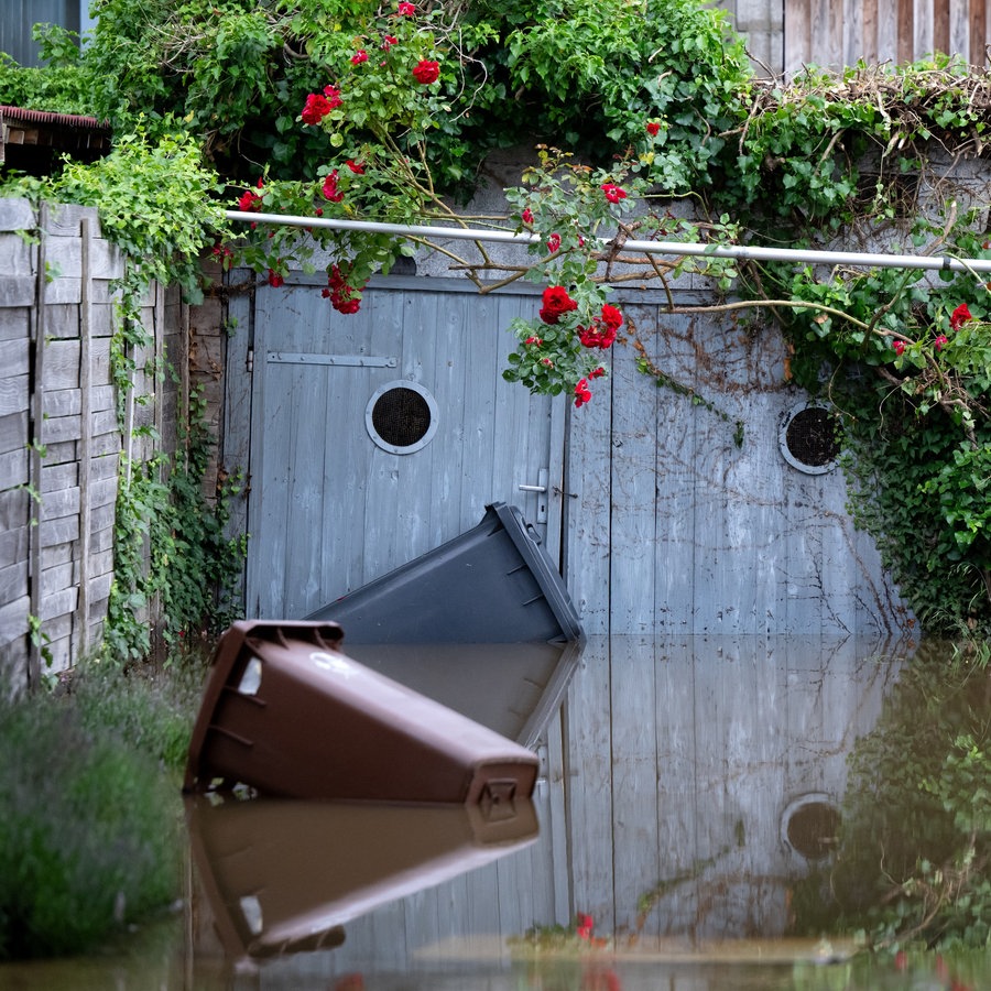 Die Einfahrt zu einer Garage samt Garten ist vom Wasser überflutet. © picture alliance Foto: Sven Hoppe