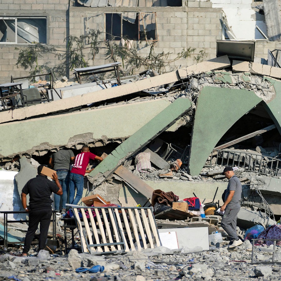 Palästinenser inspizieren die Trümmer einer Schule in Deir al-Balah im Gazastreifen, die bei einem israelischen Luftangriff zerstört wurde. © AP/dpa Foto: Abdel Kareem Hana