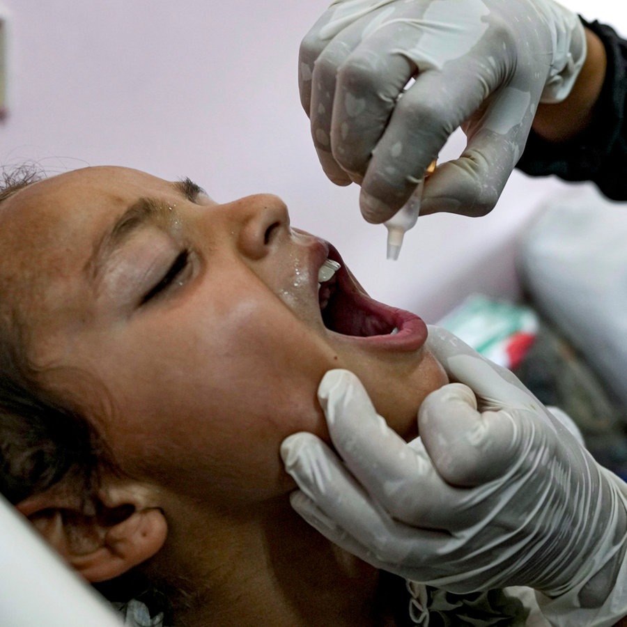 Ein Mitarbeiter des Gesundheitswesens verabreicht einem Kind in einem Krankenhaus eine Polio-Impfung. © AP/dpa Foto: Abdel Kareem Hana