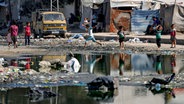 Palästinenser inspizieren die Trümmer einer Schule in Deir al-Balah im Gazastreifen, die bei einem israelischen Luftangriff zerstört wurde. © AP/dpa Foto: Abdel Kareem Hana