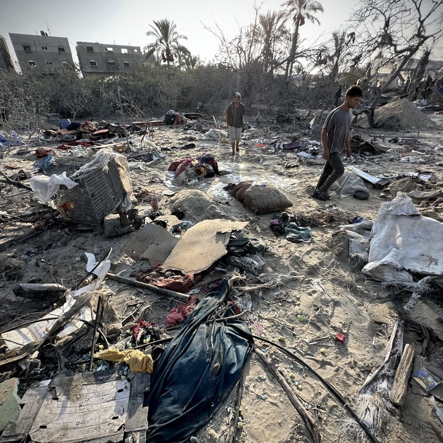 Palästinenser suchen nach einem israelischen Luftangriff auf das Zeltlager Khan Yunis nach brauchbaren Gegenständen in den Trümmern. © picture alliance / Anadolu Foto:  Abdallah F.s. Alattar