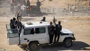 Kämpfer der Terrororganisation Hamas fahren bewaffnet in einem Jeep in Rafah im Gazastreifen (Israel). © AP/dpa Foto: Jehad Alshrafi