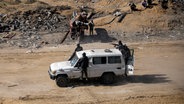 Kämpfer der Terrororganisation Hamas fahren bewaffnet in einem Jeep in Rafah im Gazastreifen (Israel). © AP/dpa Foto: Jehad Alshrafi