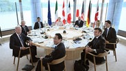 Die Teilnehmer des G7-Gipfels in Hiroshima sitzen während eines gemeinsamen Treffens an einem Tisch © picture alliance / ASSOCIATED PRESS | Brendan Smialowski Foto: Brendan Smialowski
