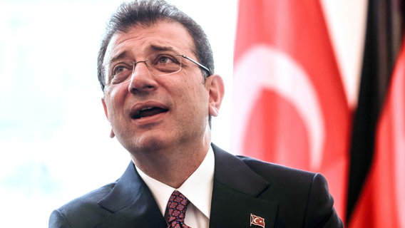 Der Oberbürgermeister von Istanbul, Ekrem Imamoglu, steht vor einer türkischen Fahne. © dpa Foto: Oliver Berg