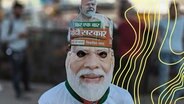 Ein Unterstützer der BJP trägt eine Maske des indischen Premierministers Narendra Modi © picture alliance 