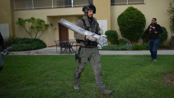 Ein israelischer Bombenentschärfer trägt die Überreste einer Rakete, die angeblich aus dem Libanon auf den Kibbuz Kfar Blum abgefeuert wurde. © AP Foto: Ohad Zwigenberg