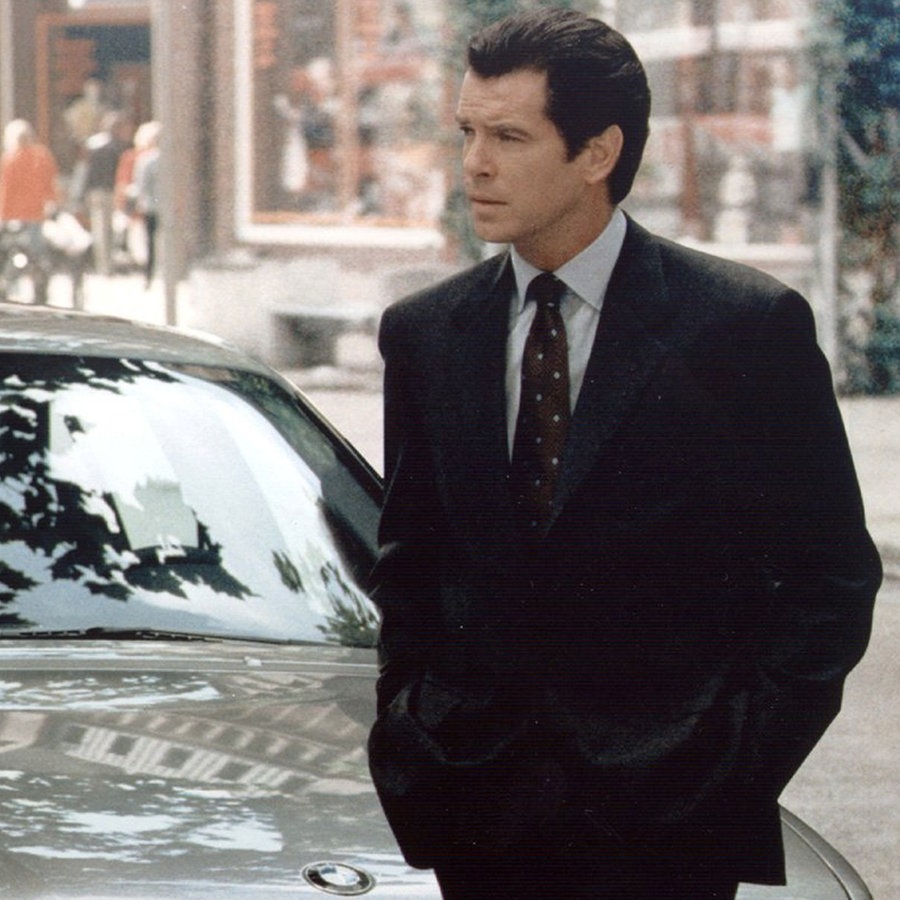 Das Archivbild von 1997 zeigt Pierce Brosnan vor seinem "Dienstwagen", einem BMW 750 iL, in einer Szene des James-Bond-Films "Der Morgen stirbt nie". © picture-alliance / dpa | dpa-Film_BMW 