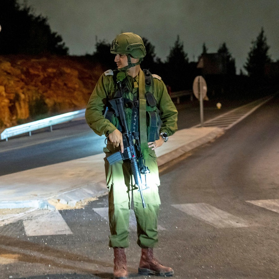 Ein israelischer Soldat steht in der Nähe des Tatorts einer Autoexplosion in der Siedlung Karmei Tzur im Westjordanland Wache. © AP/dpa Foto: Ohad Zwigenberg