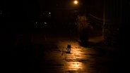 Menschen laufen nachts während einer Stromsperre in Kiew über eine Straße. © Andrew Kravchenko Foto: AP/dpa