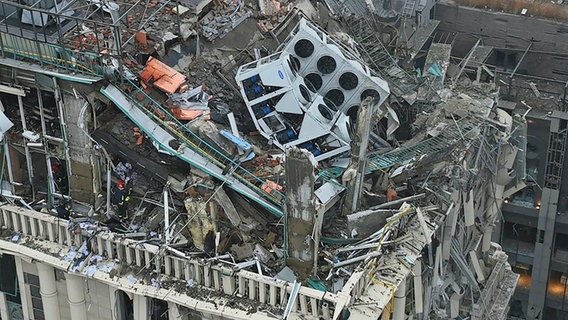 Feuerwehrleute arbeiten an einem beschädigten Gebäude nach einem russischen Raketenangriff in Kiew (Ukraine). © Uncredited/Ukrainian Emergency Service/AP/dpa 