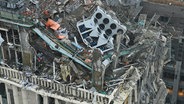 Feuerwehrleute arbeiten an einem beschädigten Gebäude nach einem russischen Raketenangriff in Kiew (Ukraine). © Uncredited/Ukrainian Emergency Service/AP/dpa 