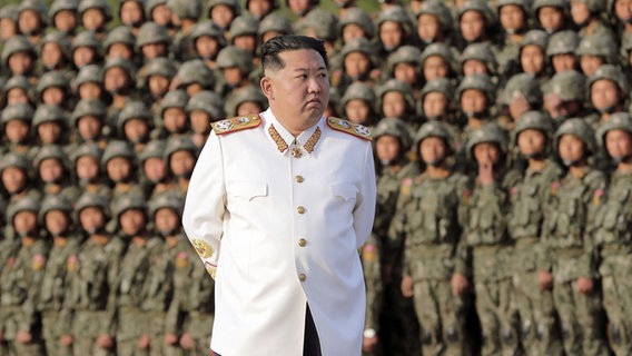 Der Machthaber von Nordkorea, Kim Jong Un, steht in einer weißen Marshal-Uniform vor nordkoreanischen Soldaten  in Pjöngjang. © nordkoreanischen Nachrichtenagentur KCNA/dpa Foto: KCNA