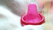 Rotes Kondom auf Bettdecke, Symbolfoto Prostitution © picture alliance / Bildagentur-online/Ohde | C.Ohde/Bildagentur-online 