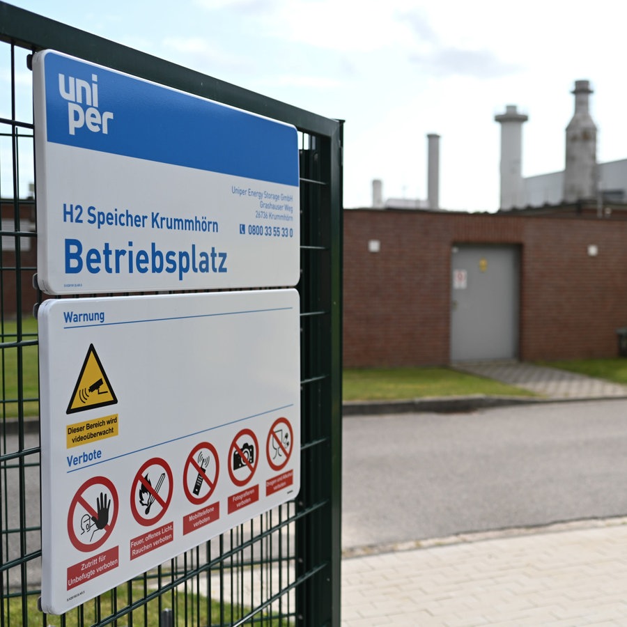 Ein Schild mit Warnhinweisen hängt vor dem Betriebsgelände einer Wasserstoff-Speicheranlage des Energiekonzerns Uniper an einem Zauntor. © picture alliance Foto: Lars Penning