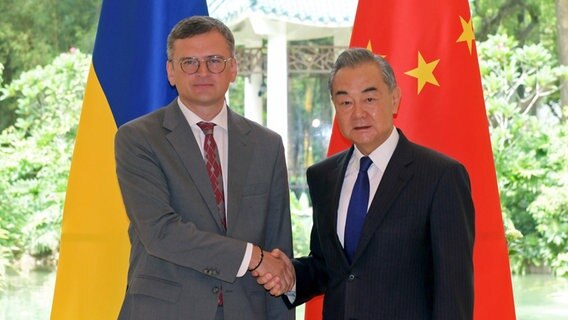 Der chinesische Außenminister Wang Yi (rechts) gibt dem ukrainischen Außenminister Dmytro Kuleba (links) bei einem Treffen in Guangzhou (China) die Hand. © XinHua/dpa Foto: Lu Hanxin