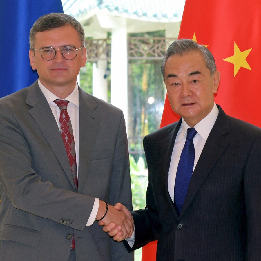 Der chinesische Außenminister Wang Yi (rechts) gibt dem ukrainischen Außenminister Dmytro Kuleba (links) bei einem Treffen in Guangzhou (China) die Hand. © XinHua/dpa Foto: Lu Hanxin