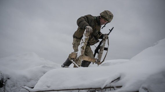 Ein ukrainischer Soldat läuft durch Schnee an der Front in Kupiansk in der Region Donezk am 21. November © picture alliance Foto: Ozge Elif Kizil