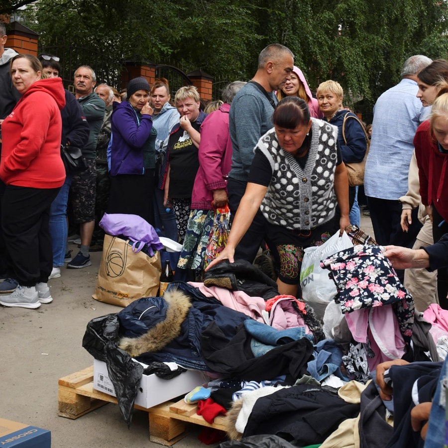 Menschen, die vor den Kämpfen zwischen russischen und ukrainischen Streitkräften evakuiert wurden, warten in einem Verteilungszentrum auf humanitäre Hilfe. © picture alliance/dpa/AP | Uncredited 