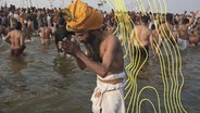 Ein Sadhu oder heiliger Hindu betet, bevor er ein heiliges Bad im Sangam nimmt, dem Zusammenfluss von Ganges, Yamuna und dem mythischen Saraswati, am "Mauni Amavasya" oder Neumondtag während des Maha Kumbh Festivals. © picture alliance/dpa/AP Foto: Deepak Sharma