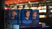 Ein Aufsteller mit Ausgaben des Buchs «Freiheit. Erinnerungen 1954 - 2021» von Ex-Kanzlerin Angela Merkel steht im Kulturkaufhaus Dussmann in der Berliner Friedrichstraße. © dpa Foto: Leonie Asendorpf