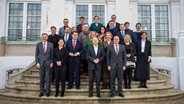 Das Kabinett um Bundeskanzler Olaf Scholz (SPD) steht beim Gruppenfoto vor Schloß Meseberg. © dpa Foto: Michael Kappeler