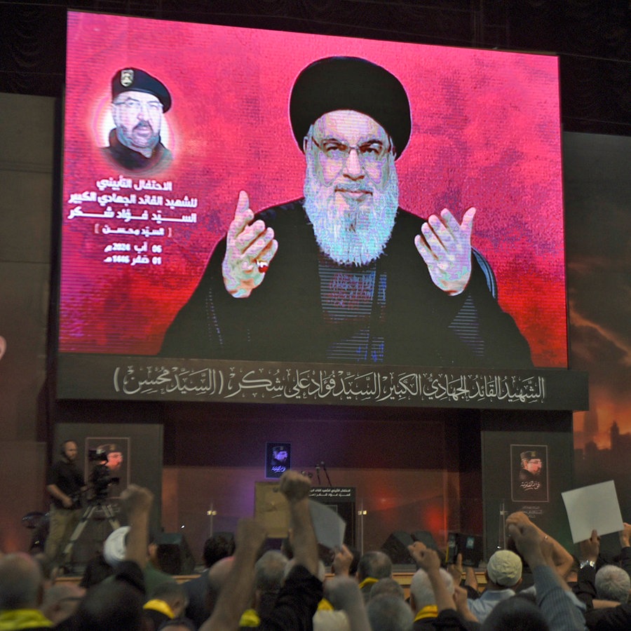 Anhänger jubeln in Beirut (Libanon), während sie eine Rede des Hisbollah-Führers Nasrallah auf einem Bildschirm verfolgen (Archivbild). © AP/dpa Foto: Mustafa Jamalddine