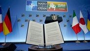 Vor Beginn einer Veranstaltung mit den Staats- und Regierungschefs der G7-Staaten und dem ukrainischen Präsidenten Selenskyj am Rande des Nato-Gipfels, wird das Dokument einer gemeinsamen Erklärung zur Unterstützung der Ukraine präsentiert. © AP/dpa Foto: Susan Walsh