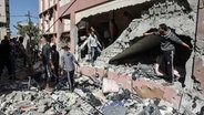 Menschen begutachten die Shuhada-Schule in Nuseirat (Gazastreifen), die von einem israelischen Luftangriff getroffen wurde. © APA Images via ZUMA Press Wire/dpa Foto: Omar Ashtawy Apaimages