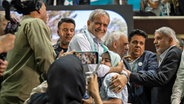 Der neue Präsident vom Iran, Massud Peseschkian (Mitte), umarmt bei einer Veranstaltung in der Hauptstadt Teheran seine Enkeltochter. © Arne Immanuel Bänsch/dpa 