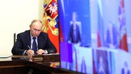 Wladimir Putin hält in seiner Residenz in Nowo-Ogaryowo eine Videokonferenz zur Lage in den russischen Regionen Belgorod, Brjansk und Kursk ab. © picture alliance / Russian Look | Kremlin Pool 