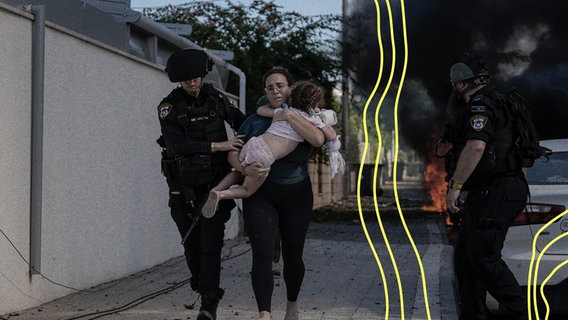 Israelische Polizisten evakuieren eine Frau und ein Kind von einem Ort, der von einer aus dem Gazastreifen abgefeuerten Rakete getroffen wurde, in Aschkelon, Süd-Israel, am Samstag, den 7. Oktober 2023. © picture alliance Foto: ASSOCIATED PRESS