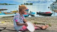 Eine Fischerin sitzt am Ufer am Fischmarkt Auki auf den Salomonen. © NDR Foto: Kathrin Erdmann